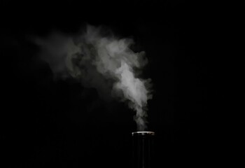 Poster - White wispy smoke rises from the top of a dark object against a black background.
