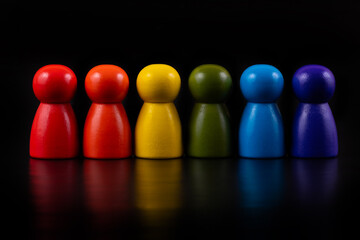 multi-colored symbolic figures of wooden people on a black background