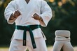 © kang - Karateka in White Gi, Focused Posture, Serene Outdoor Setting