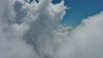 Wall Mural - flying through white fluffy clouds