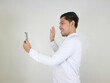 © vicky - Asian man in a white formal shirt is making a video call with someone on the cellphone he is holding, with a gesture of greeting someone