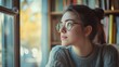 © aun - A student with a thoughtful expression, looking out the window in a quiet study space, envisioning their life goals