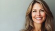 © ORG - A vibrant portrait of a middle-aged American woman smiling confidently, her radiant complexion and natural beauty featured against a minimalist background.