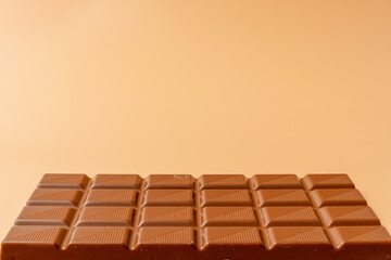 Wall Mural - A chocolate bar with a white background. The chocolate bar is cut into squares. The squares are all different sizes