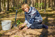 © dimmas72 - A woman plants a young oak tree.