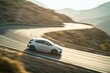 © Maria - sporty hatchback captured mid-turn on curving mountain road with motion blur adding sense of speed