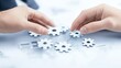 © Agusti - Two hands connecting gears, symbolizing collaboration and teamwork.