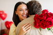 © Home-stock - Happy Valentine's Day. Man giving bouquet of red roses to his beloved woman, lady embracing husband tenderly. Romantic evening at home