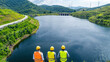 © Александр Марченко - Engineers analyzing a hydroelectric power plant dam and reservoir