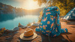 © Andrea - Travel image at lake with blue and yellow floral print luggage backpack bag, sun hat. Vacation tent camping hiking explore wandering adventure weekend trip lifestyle or spring break sunny getaway.