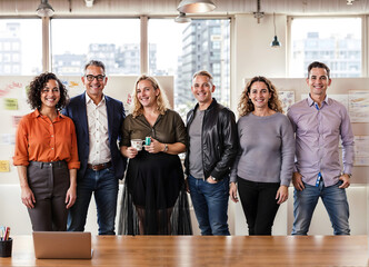 A group posing for a picture in front of an Apple laptop