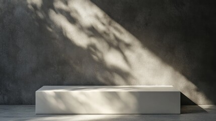 Wall Mural - Minimalist white platform against a textured dark grey wall with dappled sunlight.