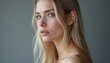 © natakot - This captivating image features a close-up profile of a beautiful blonde woman with soft, flowing hair and striking blue eyes. Her natural beauty radiates tranquility and grace, evoking a sense of