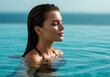 © IbragimovN - Serene woman relaxing in infinity pool with ocean view at sunset