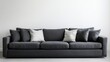© G.Go - A large black couch with white pillows on it