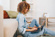© SHOTPRIME STUDIO - Comfortable Freelance: Smiling Woman Typing on Laptop in Cozy Living Room