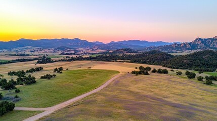 Wall Mural - Breathtaking Countryside Landscape with Majestic Mountains and Glowing Sunset Sky