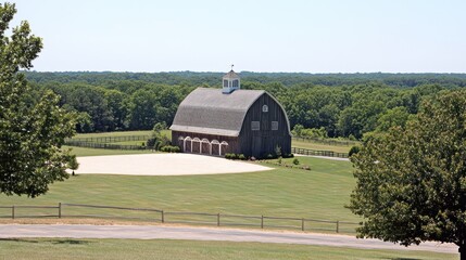 Wall Mural - Scenic view of a rustic barn nestled in a green field, surrounded by trees and a light-colored arena.