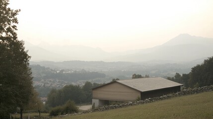 Sticker - Serene mountain vista with a small building nestled in the valley.  Misty mountains and a tranquil valley landscape.