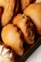 Poster - Delicious assortment of freshly baked pastries displayed on a wooden tray in a cozy bakery setting