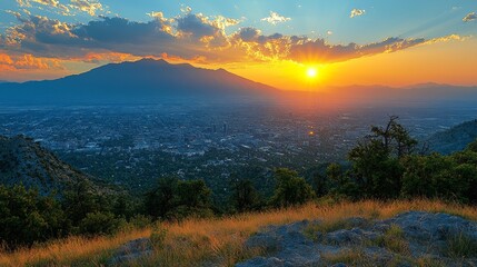 Wall Mural - Panoramic sunset view over city nestled in mountains.