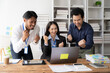 © Wicitr - Team Success: Three diverse professionals celebrate their success, hands raised in triumph, in front of a laptop.  The vibrant energy and shared joy capture the essence of teamwork and accomplishment.