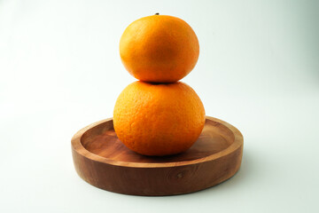 Ripe tangerines orange on wooden plate. Isolated on white background. Concept for Chinese Lunar New Year.