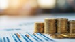 © AucArtStudio - Tax incentive concept. Stacks of gold coins on financial reports with charts in the background.