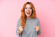 © luismolinero - Young caucasian woman isolated on pink background celebrating a victory in winner position