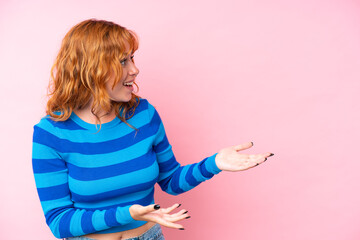 Wall Mural - young caucasian woman isolated on pink background with surprise expression while looking side