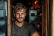 © Pinklife - A handsome young man with captivating blue eyes stands proudly at the entrance of a café, embodying the essence of charm and confidence in a relaxed atmosphere.