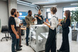 © standret - Gathering, looking at printed product. People are in the office by the 3d printer