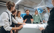© standret - Explaining how the device works. People are in the office by the 3d printer