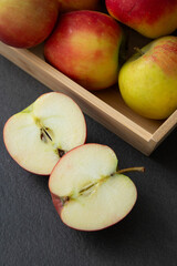 Wall Mural - Fresh small organic red apples in a wooden crate on grey table background