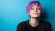 © Vivid_Vision - A non-binary person in their 20s with purple hair, wearing a black T-shirt, playful expression