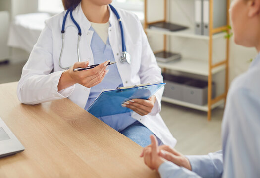 Close up shot of a doctor or nurse hands during a medical consultation and conversation with a patient in the hospital. This interaction highlights healthcare, examination, and patient treatment.