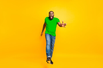 Wall Mural - Full length body size photo of angry furious yelling commanding black man wearing jeans denim screaming into camera while isolated with yellow vivid background