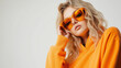 © Erwin - A striking fashion portrait of a young Caucasian woman in trendy orange sunglasses and hoodie, exuding confidence and modern style, embodying contemporary fashion trends and trends.