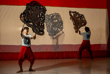 Wall Mural - Asian young men show or perform grand shadow play together to present Thai culture and traditional performance for tourist and the other people and conservation good culture.