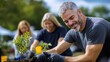© S@photo - Smiling Man Planting Young Tree with Friends in Outdoor Garden Event
