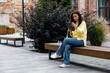 © Oleksii Syrotkin/Stocksy - Young asian woman student or employee using digital tablet on bench