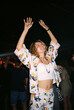 © Viktor Solomin/Stocksy - Young woman dancing joyfully in colorful outfit at a lively party