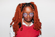 © Viktor Solomin/Stocksy - Young black girl with vibrant orange twisted hair wearing glasses