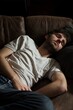 © StockUp - A young man rests peacefully on a leather couch, showcasing tranquility and comfort.