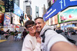 © Alvaro Lavin/Stocksy - Happy tourists couple taking selfie in times square, new york city