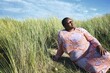 © Studio Sincère/Stocksy - Woman resting in vibrant grass under sunny sky