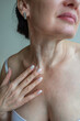 © Olena Smyrnova/Stocksy - Portrait of mature woman applying cream on her neck