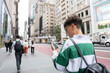 © Alvaro Lavin/Stocksy - Tourist using smartphone and walking in manhattan, new york city