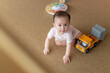 © Marc Tran/Stocksy - Cute Baby Playing on Carpet with Toy Truck and Curious Look