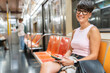 © Alvaro Lavin/Stocksy - Young woman using smartphone while riding new york city subway